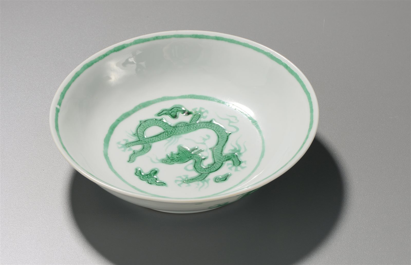 白釉暗刻海水绿龙纹盘